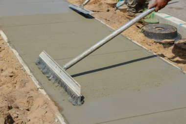 İşçiler kence sırasında yeni çimento üzerinde beton yüzeyi bitirir ve pürüzsüz hale getirirler
