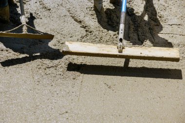 Kaldırımın önündeki çimento yeni kaldırımda inşaat işçisi beton yüzeyi altında yeni bir bina.