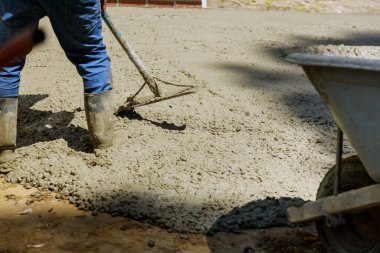 Temel oluşturma sürecinde inşaat işçileri el arabası ve el arabası ile beton işçiler.
