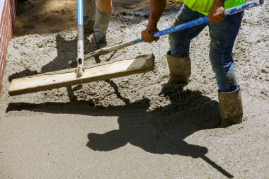 İnşaat alanındaki işçiler beton temeller oluşturma sürecinde inşaat işçilerini çimento işçileriyle dolduruyorlar