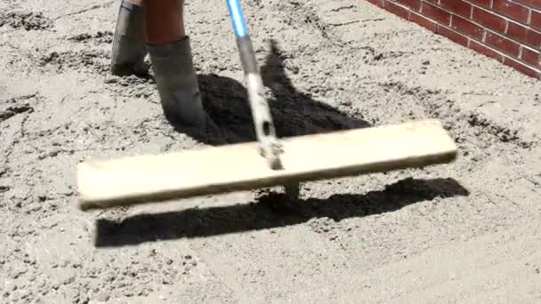 Trabajador de la construcción vierte cemento para acera en obras de hormigón con carretilla — Vídeo de stock