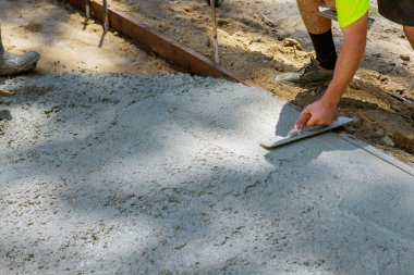 İnşaat müteahhitliği sırasında beton çimentoyu şamandıra kullanarak sıvayan bir işçi.