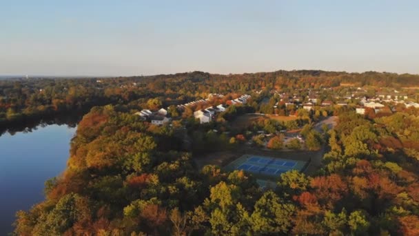 Pemandangan perumahan rumah-rumah pribadi atap dengan daerah sepanjang sungai di kapal pesiar parkir pohon maple musim gugur — Stok Video
