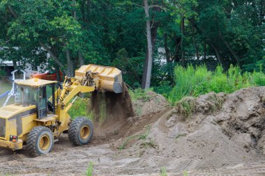 Buldozer peyzajı Dünya ile çalışırken aynı zamanda kazıcı üzerinde çalışıyor.