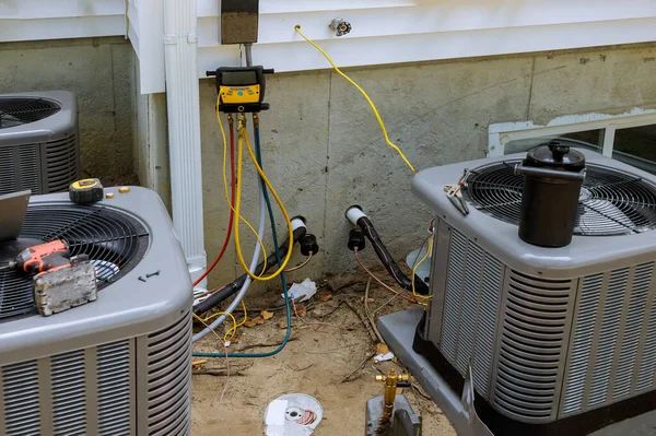 Air conditioning technician servicing of preparing to install new air conditioner refueling the air conditioner with freon