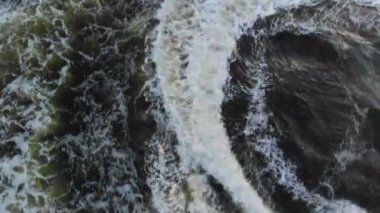 Gök mavisi sularda yüzen bir teknenin insansız hava görüntüsü.