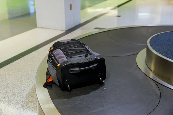 Suitcase or luggage with conveyor belt in the baggage claim at the airport