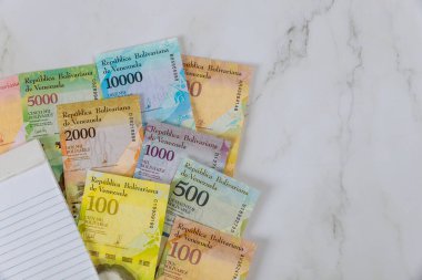 Venezuela ekonomisi üzerine boş bir defter farklı kağıt para birimleri olan banknotlar Venezuela Bolivar,