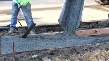 İnşaat alanındaki inşaat işçileri yeni kaldırım betonu oluşturma sürecinde inşaat işçilerini çimento işçileriyle dolduruyorlar