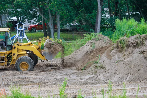 Landscaping works on the bulldozer moves soil digging ground construction earthmoving