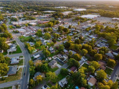 Yükseklerden Panorama. Kırsal kesimde küçük bir Amerikan kasabası. Gün batımında çatılar.
