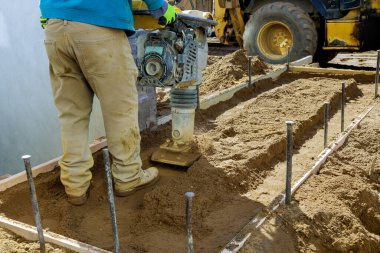 İşçi sıkıştırılmış kum özel çalışma aracı titreşim plakası ile yeni kaldırım etrafında