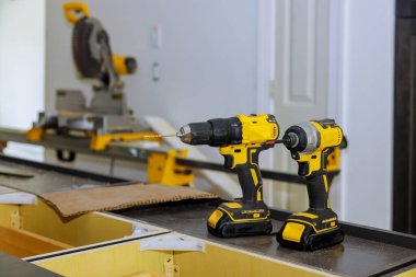 Matkap ucu ile çalışan iki kablosuz matkap aynı zamanda matkap aletinde tornavida silahı olarak çalışan profesyonel ahşap işçiliği aracı