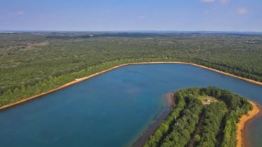 Ormanda gölün üstünde bulutlar olan güzel bir manzara.