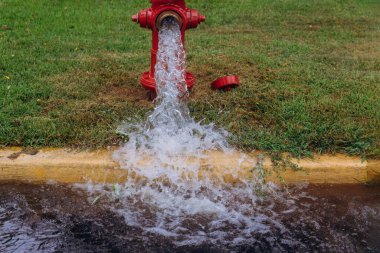 Sokaktaki yangın musluğundan akan açık yangın musluğu suyu.