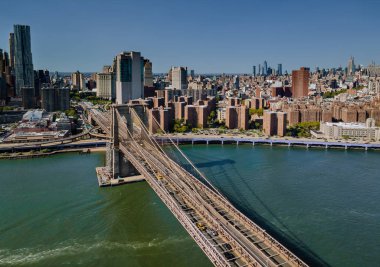 Brooklyn Köprüsü 'nden Doğu Nehri' ne, oradan da Manhattan Bölgesi 'ne geri uçuyor..