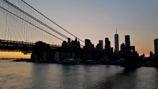 Brooklyn-Brücke in der Abenddämmerung an der Skyline von Lower Manhattan am East River in New York, New York, USA — Stockvideo
