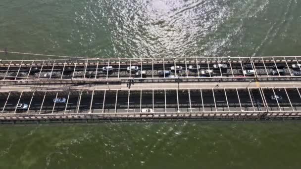 Aerial flight over Brooklyn Bridge with American flag waving view over East River New York City U.S. — Stock Video