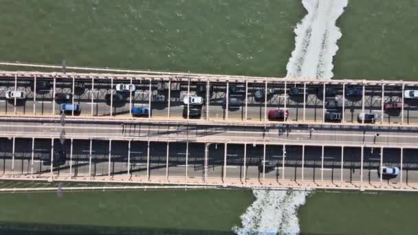 Aerial flight over Brooklyn Bridge with American flag waving view over East River New York City U.S. — Stock Video