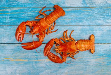 Lezzetli deniz ürünleriyle haşlanmış ıstakoz yemeği eski ahşap masada servis edilir..