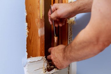 Tesisat tamircisi bakır boru temizleme tesisatı ile çalışıyor.