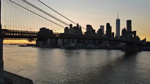 New York City Brooklyn Bridge über den Hudson River mit Skyline nach Sonnenuntergang Nachtsicht beleuchtet mit Lichtern gesehen — Stockvideo