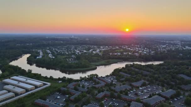 Aerial view of town along the river with residential areas of private houses on colorful clouds in the sky blue orange sunset light of the sun — Stock Video