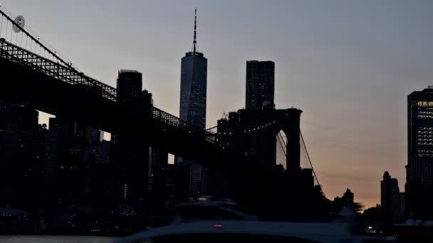 Alacakaranlıkta Brooklyn Köprüsü nehri alacakaranlıkta New York, ABD 'nin alacakaranlıkta East River' daki Lower Manhattan gökdelenlerine bakıyor. — Stok video