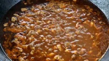 Kazanda kuzu pirzola, dışarıda pilav pişirme geleneksel Özbek yemeği.