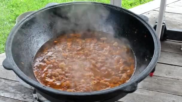 Vaření pilaf venku nasekané jehněčí smažení v kotli — Stock video