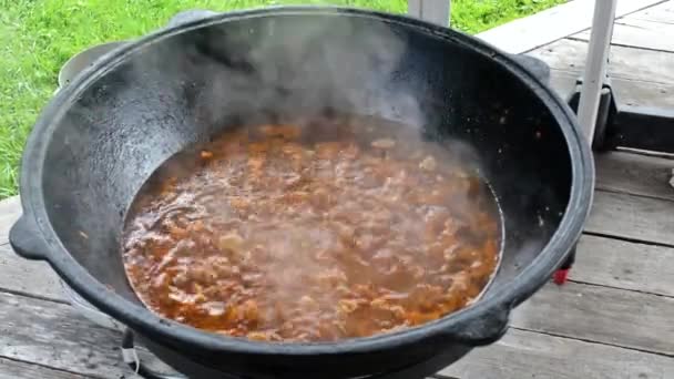 Cocción de pilaf al aire libre cordero picado freír en caldero — Vídeos de Stock