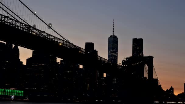 Nueva York Puente de Brooklyn sobre el río Hudson con horizonte después de la puesta del sol vista nocturna iluminada con luces vistas — Vídeos de Stock