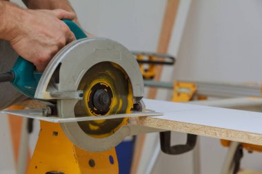 Elektrikli testere ustası dairede ahşap kaplamalı raflar kesmiş.