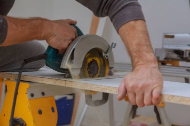 Ahşap kaplamalı beyaz rafları kesmek için Cuthand elektrikli testere