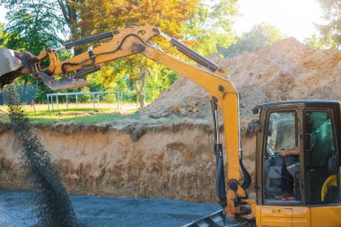 İnşaat sahası kazıcısı inşaat için çakıl ve taş taşıyor.