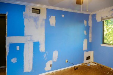 Hasarlı duvar ve duvarlar hasarlı duvarı kaplıyor, tamirat yapıyor.