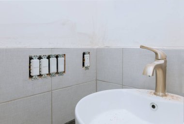 Tadilattan sonra banyo temizliği hazır lavabo ve musluk ile modern fayanslı banyo küveti