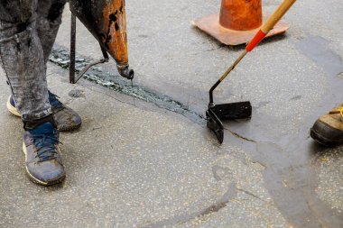 İşçide yol yüzeyi yenileme çalışmaları, bitumen emülsiyon asfalt yüzeyi ile kaplanarak çatlakların onarımını gerçekleştirir.