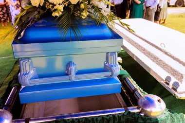 Aile ve arkadaşlar, duygusal bir veda seremonisi sırasında tabutları indirilirken saygılarını sunmak için toplandılar..