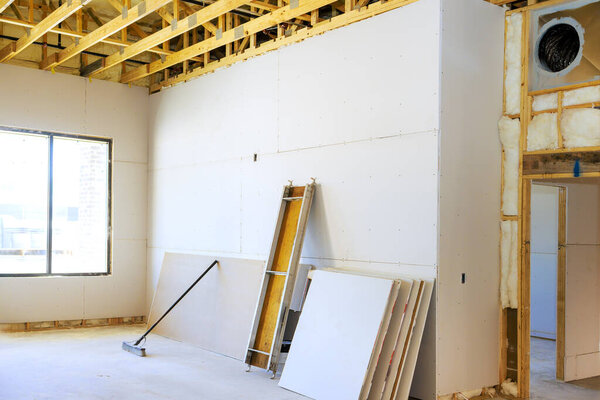 Проводится монтаж гипсокартона с обнажёнными стенами для ремонта дома.