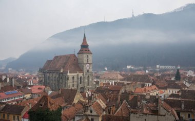 Panoramik Brasov'un tarihi kent merkezine ve Siyah Kilisesi bir sisli kış günde Karpat Dağları ile. Transilvanya, Romanya