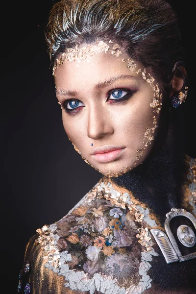 Portret van een meisje met gouden pictogram schilderij make-up — Stockfoto