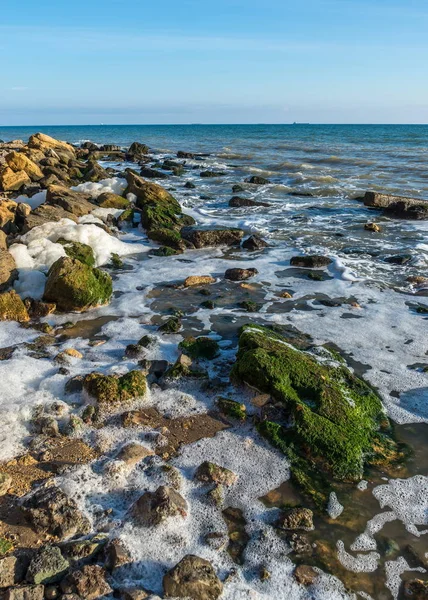 Espuma marina y piedras en la orilla — Foto de Stock