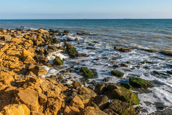 Espuma marina y piedras en la orilla — Foto de Stock