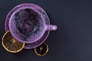 Siyah arka planda limon dilimleri olan mor kupa Cadılar Bayramı kahvesi rahat bir ev molası verdi.