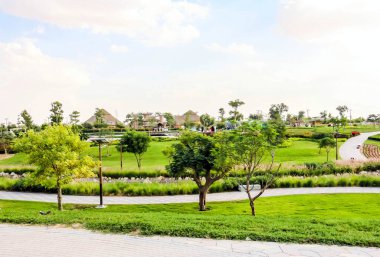 Al Warqa ve Dubai Hayvanat Bahçesi arka planındaki Dubai Safari Park zoolojik bahçesinin yemyeşil güzel manzarası, Dubai, BAE 'deki en çeşitli hayvan çeşitliliğine ev sahipliği yapıyor.