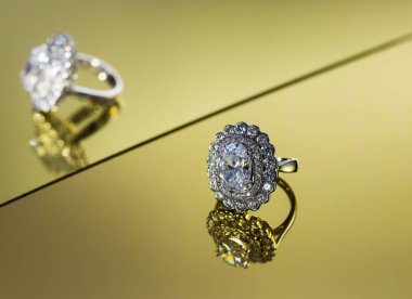 Sarı ayna stüdyosunun arka planında elmas elmaslı güzel bir yüzük ve çapraz yansıması var.