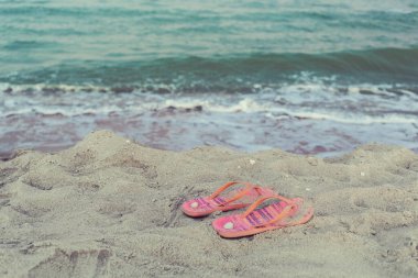 Kayıp, sol pembe ve turuncu kadın deniz manzaralı kumsalda parmak arası terlikler ve deniz manzarası ve deniz kabukları, yüzmeye gidiyor, mutlu tatil, yumuşak renkler