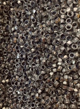 Metalin izole edilmiş arka plan desenleri yeni fındıklar, dişli delikleri olan donanım bağlayıcıları.