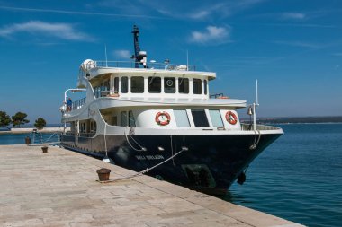 Brijuni, Hırvatistan - 30 Mart 2019: Güneşli bir günde Veliki Brijun adasında iskeleye demirleyen turist teknesi